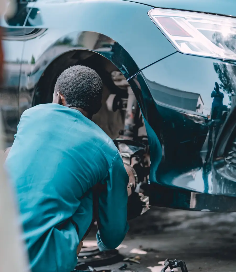 Mechanic working on a car brake at an auto repair garage